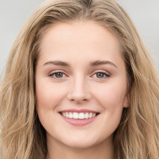 Joyful white young-adult female with long  brown hair and blue eyes