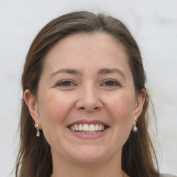 Joyful white adult female with long  brown hair and grey eyes