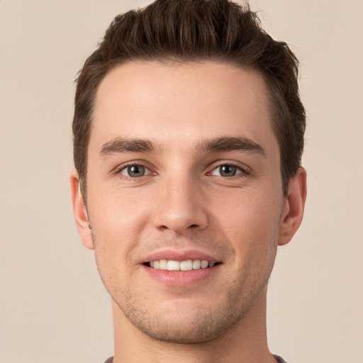 Joyful white young-adult male with short  brown hair and grey eyes