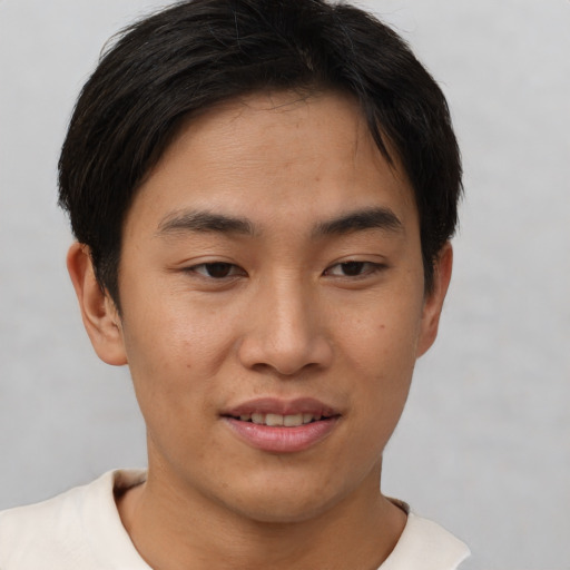 Joyful asian young-adult male with short  brown hair and brown eyes