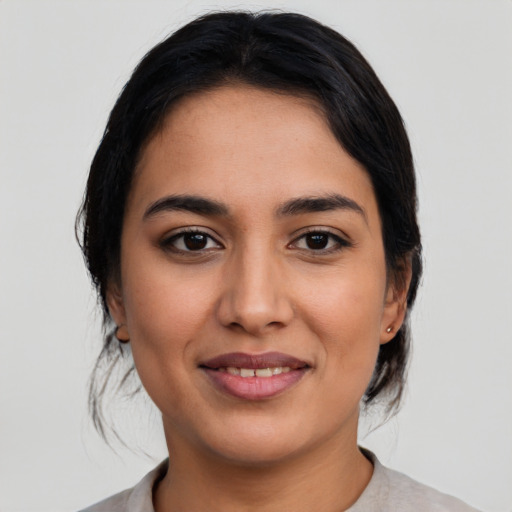 Joyful latino young-adult female with medium  black hair and brown eyes