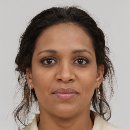 Joyful black young-adult female with long  brown hair and brown eyes
