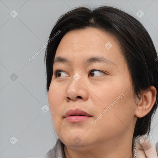 Joyful asian young-adult female with medium  brown hair and brown eyes