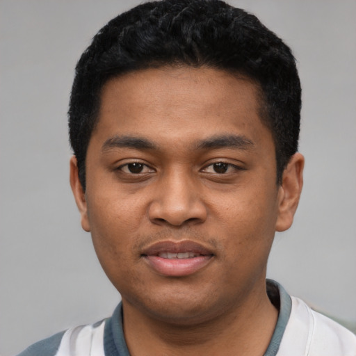 Joyful latino young-adult male with short  black hair and brown eyes