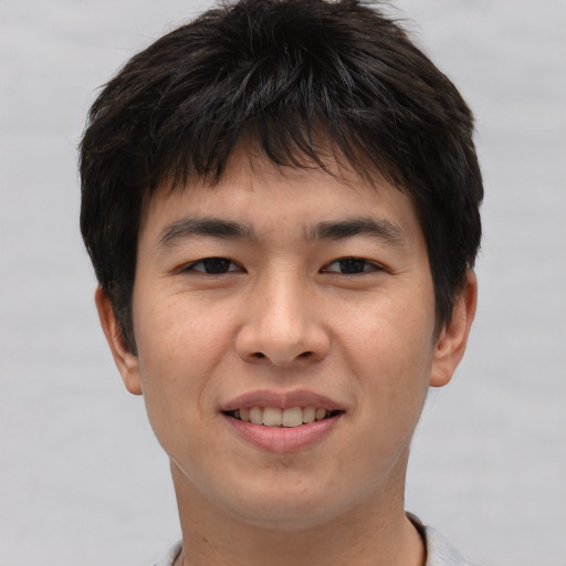 Joyful asian young-adult male with short  brown hair and brown eyes