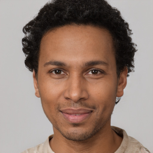 Joyful black adult male with short  brown hair and brown eyes