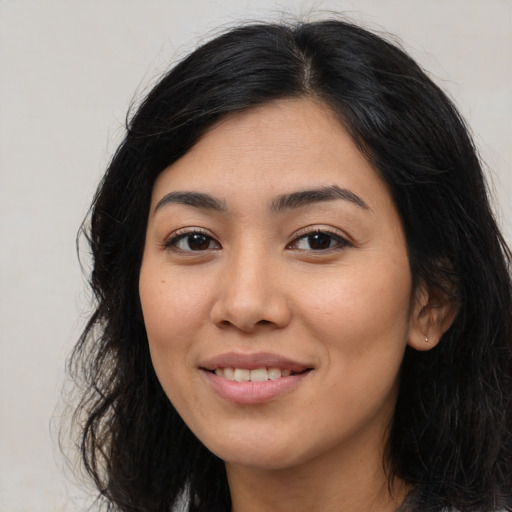 Joyful latino young-adult female with long  black hair and brown eyes