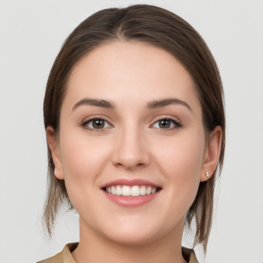 Joyful white young-adult female with medium  brown hair and grey eyes