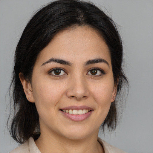 Joyful latino young-adult female with medium  brown hair and brown eyes