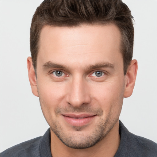 Joyful white young-adult male with short  brown hair and grey eyes