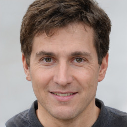 Joyful white adult male with short  brown hair and grey eyes