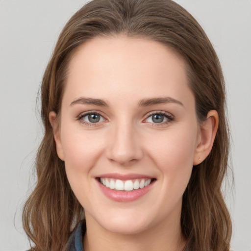 Joyful white young-adult female with long  brown hair and blue eyes