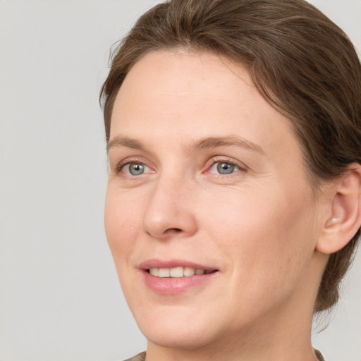 Joyful white adult female with short  brown hair and grey eyes