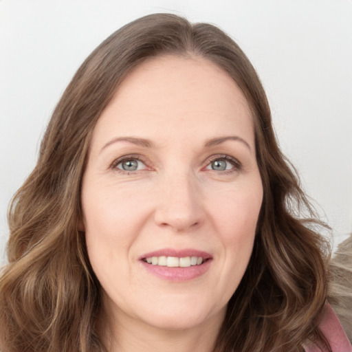 Joyful white young-adult female with long  brown hair and green eyes