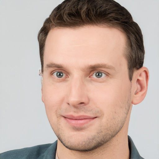 Joyful white young-adult male with short  brown hair and grey eyes