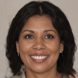 Joyful black adult female with medium  brown hair and brown eyes