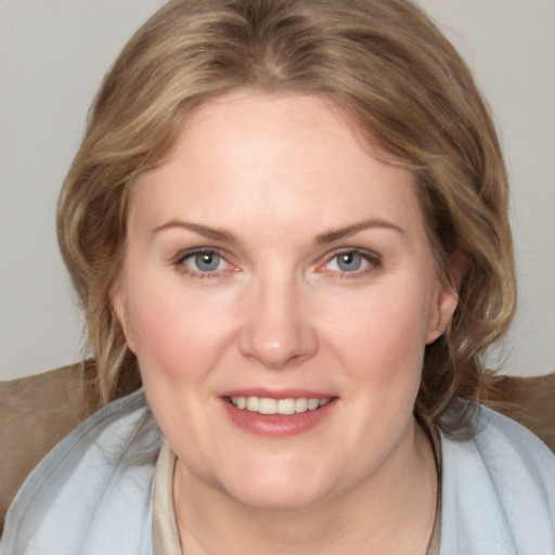 Joyful white young-adult female with medium  brown hair and blue eyes