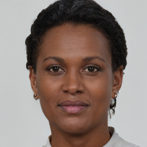 Joyful black adult female with short  brown hair and brown eyes