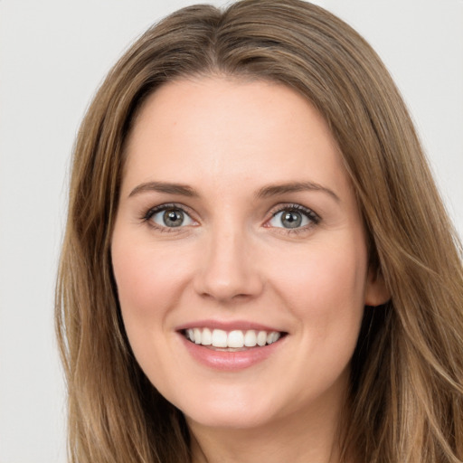 Joyful white young-adult female with long  brown hair and green eyes