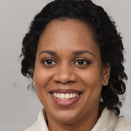 Joyful black adult female with medium  brown hair and brown eyes