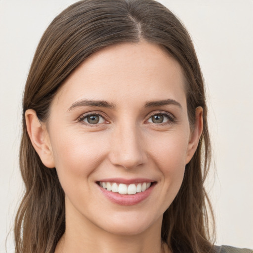 Joyful white young-adult female with long  brown hair and grey eyes