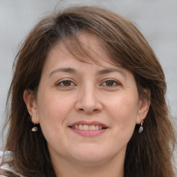 Joyful white adult female with long  brown hair and brown eyes