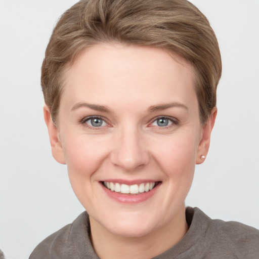 Joyful white young-adult female with short  brown hair and grey eyes