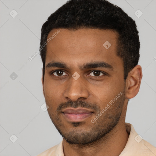 Joyful black young-adult male with short  black hair and brown eyes