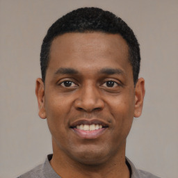 Joyful black young-adult male with short  black hair and brown eyes