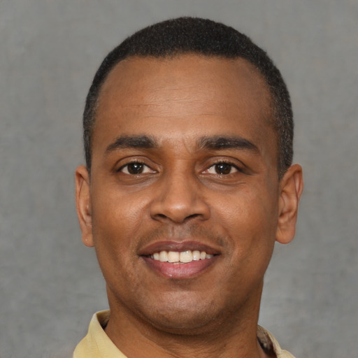 Joyful black young-adult male with short  black hair and brown eyes