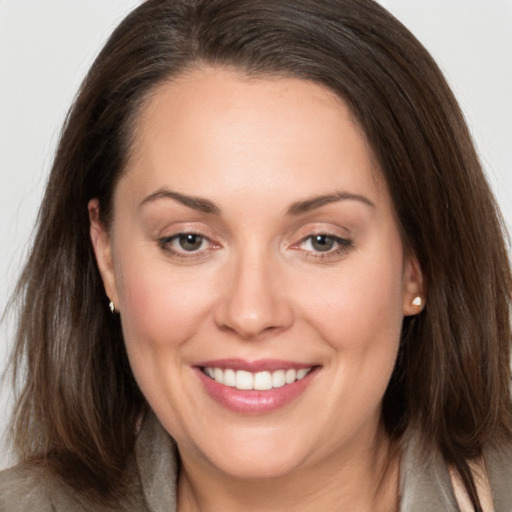 Joyful white adult female with long  brown hair and brown eyes