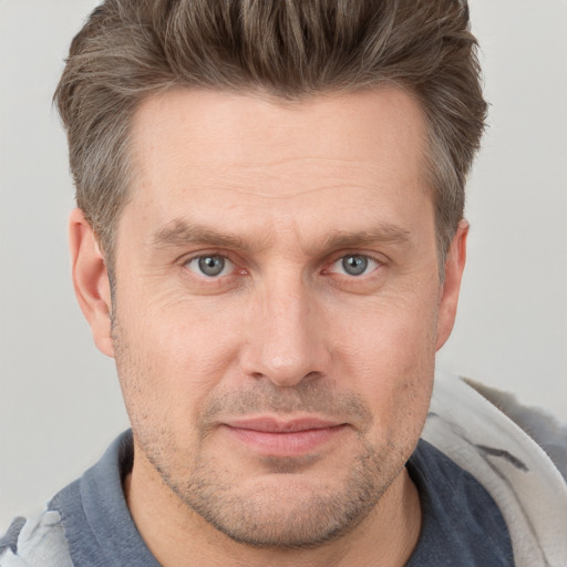 Joyful white adult male with short  brown hair and grey eyes