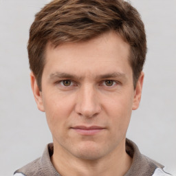 Joyful white young-adult male with short  brown hair and grey eyes