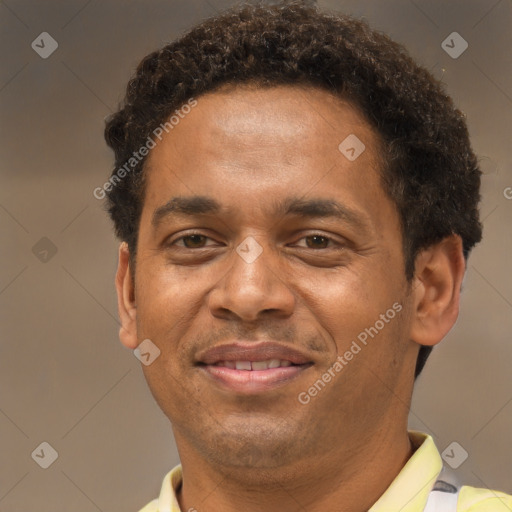 Joyful black young-adult male with short  brown hair and brown eyes