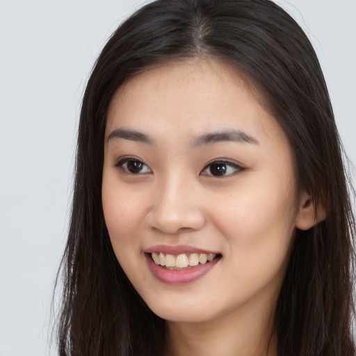 Joyful asian young-adult female with long  brown hair and brown eyes