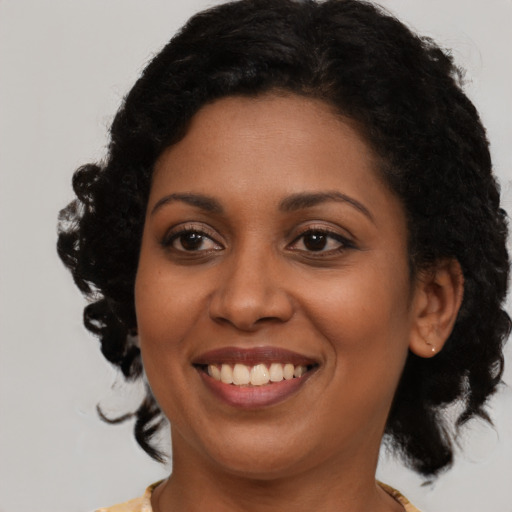 Joyful black young-adult female with medium  brown hair and brown eyes