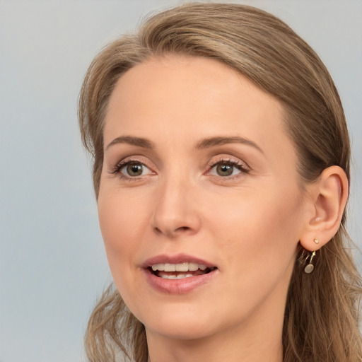 Joyful white adult female with long  brown hair and grey eyes