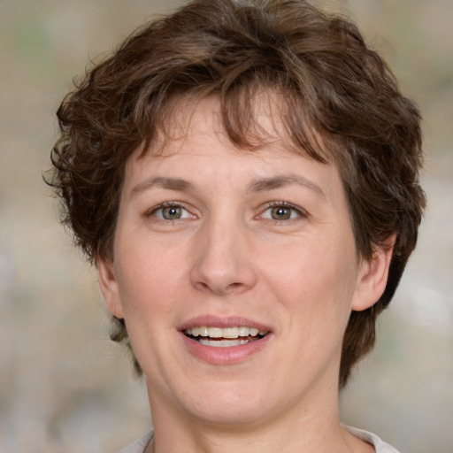 Joyful white adult female with medium  brown hair and green eyes