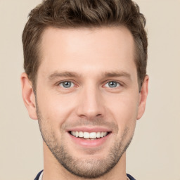 Joyful white young-adult male with short  brown hair and grey eyes