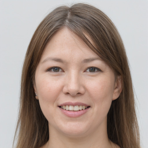 Joyful white young-adult female with long  brown hair and grey eyes