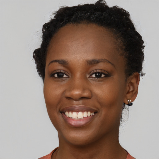Joyful black young-adult female with short  black hair and brown eyes