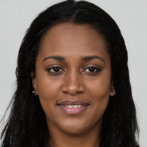Joyful black young-adult female with long  black hair and brown eyes