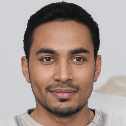 Joyful latino young-adult male with short  black hair and brown eyes