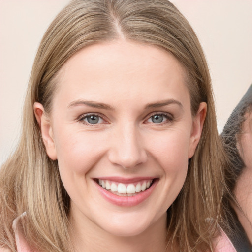 Joyful white young-adult female with long  brown hair and blue eyes