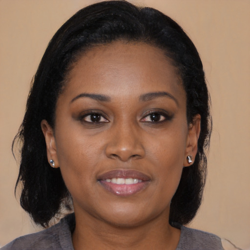 Joyful black young-adult female with medium  brown hair and brown eyes