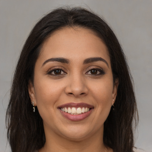 Joyful latino young-adult female with long  brown hair and brown eyes