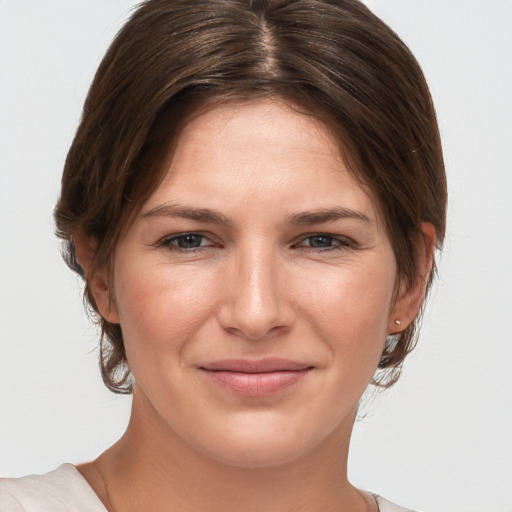 Joyful white young-adult female with medium  brown hair and grey eyes