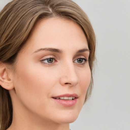 Joyful white young-adult female with medium  brown hair and green eyes