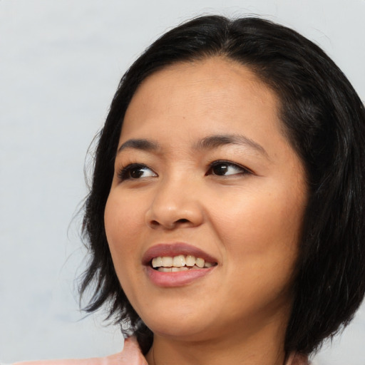 Joyful asian young-adult female with medium  black hair and brown eyes