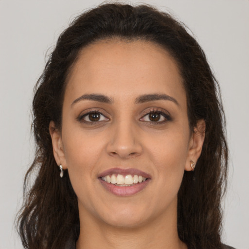 Joyful latino young-adult female with long  brown hair and brown eyes